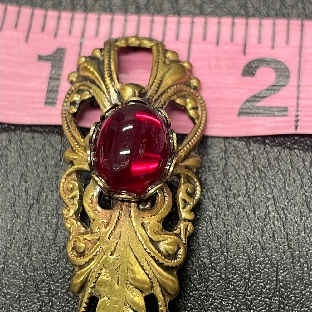 Filigree gold toned, brooch pin with red stone